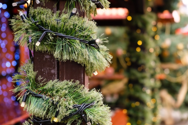 Christmas Decorated City Fair of Lighting LED Garland and New Year Tree branch at Winter day