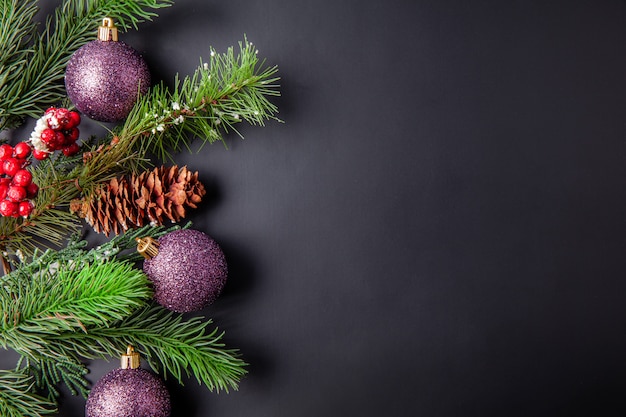 Christmas decoration black background with christmas balls and pines