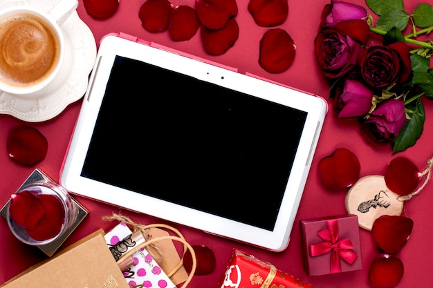 Christmas decoration and gift. Morning fragrant coffee and rose petals. Top view. Different subjects on a red background. Copy space, flat lay,