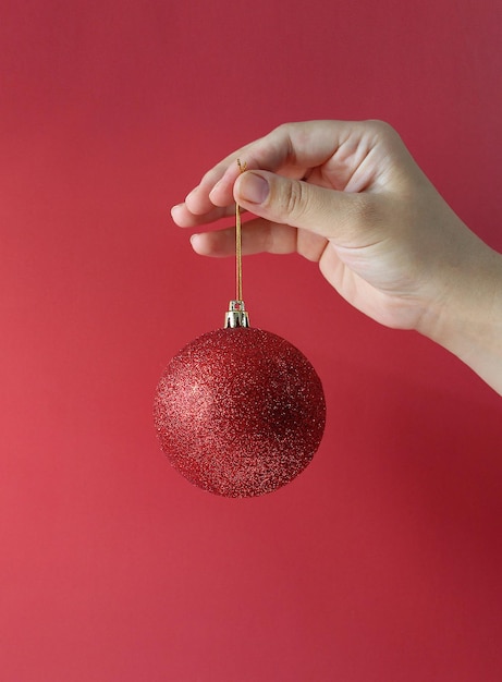 Christmas decoration holidays and people concept close up of woman hand holding christmas ball