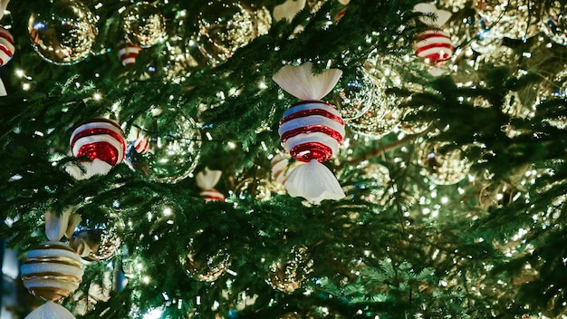 Christmas decoration and lights and candies on green tree