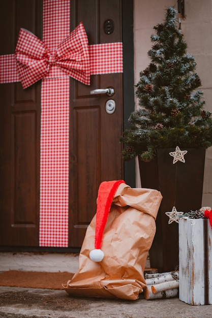 Christmas decoration of the porch of the house The entrance door is decorated with a large red bow