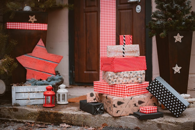 Christmas decoration of the porch of the house. The entrance door is decorated with a large red tied bow. New Year, Xmas, festive atmosphere handmade