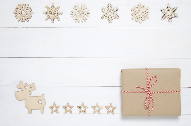  Christmas decoration, reindeer and gift box on white wooden table.