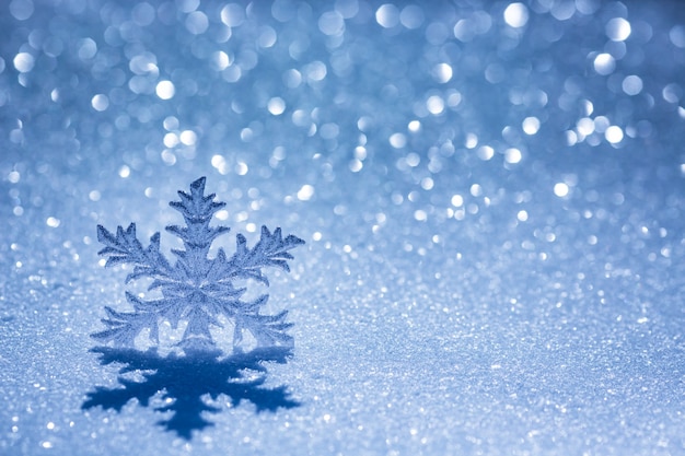 Christmas decoration on snow against blurred lights background