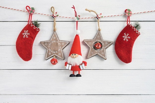 Christmas decoration on white wooden background. Copy space. Santa Claus, Christmas socks and wooden stars on white background.