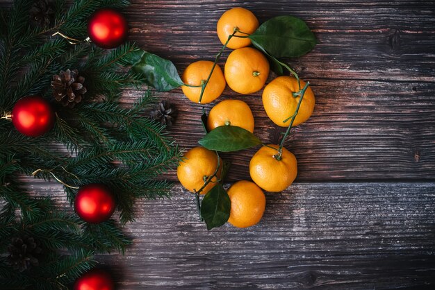 Christmas decoration with tangerines, fir branches, red balls. Traditional festive winter decor for the new year