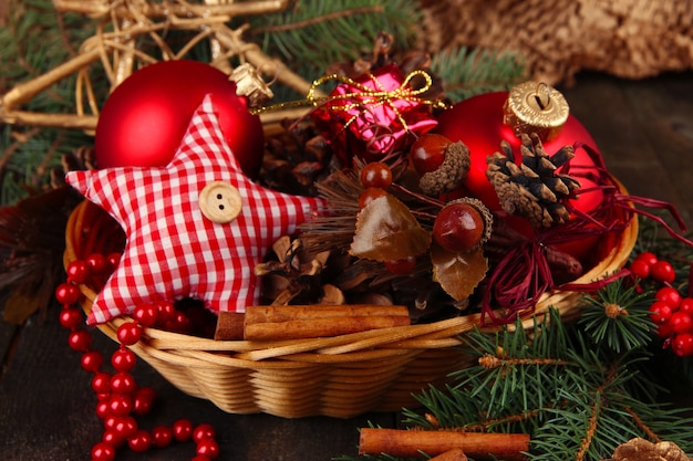 Christmas decorations in basket and spruce branches on table close up