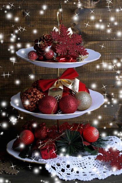 Christmas decorations on dessert stand, on wooden background