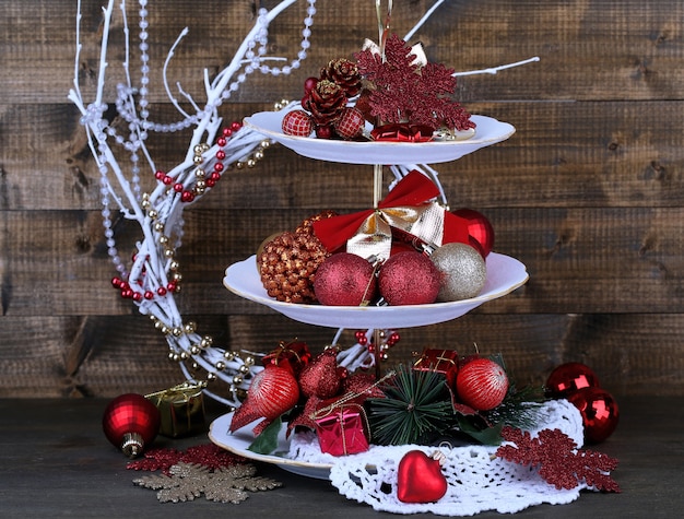 Christmas decorations on dessert stand, on wooden background