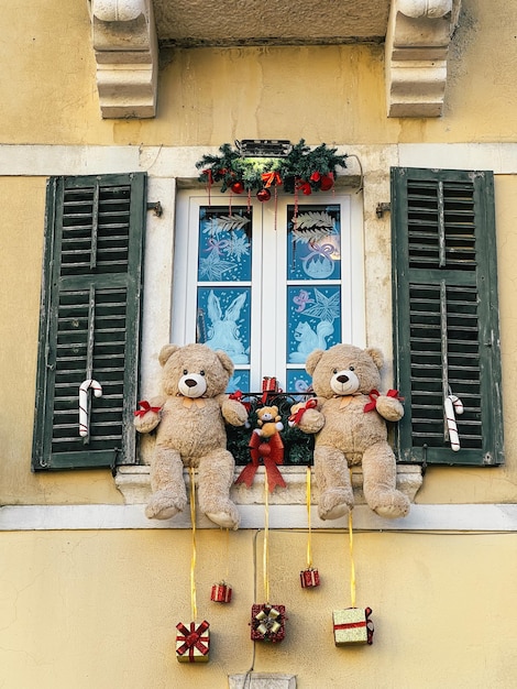 Christmas decorations hanging from the window sill of an old stone house