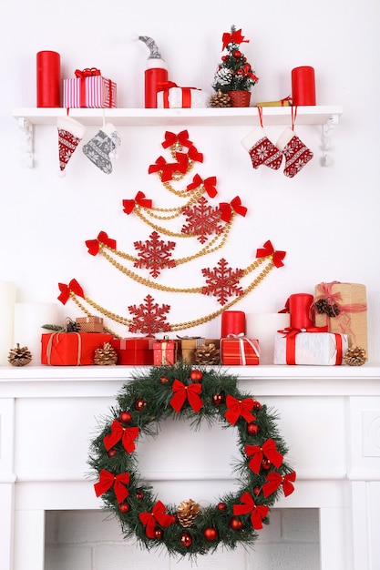 Christmas decorations on mantelpiece on white wall background