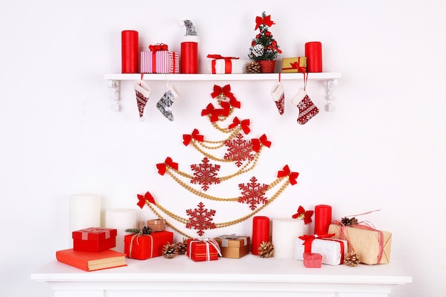 Christmas decorations on mantelpiece on white wall