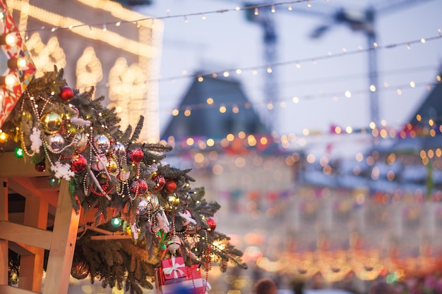 Christmas decorations and New Year tree with colorful lights on a city street during the festive winter fair. Concept of christmas holidays