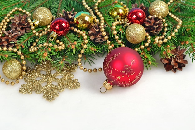 Christmas decorations and spruce branch and cones on a white