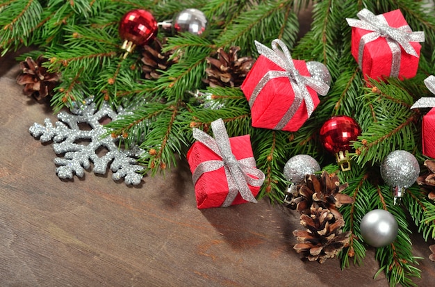 Christmas decorations and spruce branch and cones on a wooden background