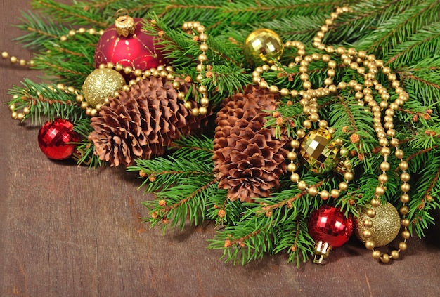 Christmas decorations and spruce branch and cones on a wooden background