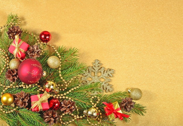 Christmas decorations on a spruce branch on a golden background