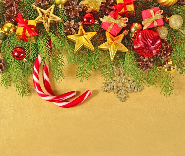 Christmas decorations on a spruce branch on a golden background