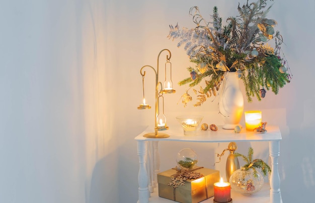 Christmas decorations with burning candles on white background at the evening