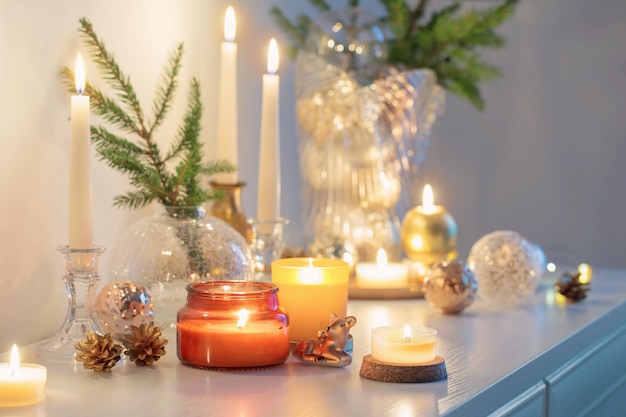 Christmas decorations with burning candles in white room