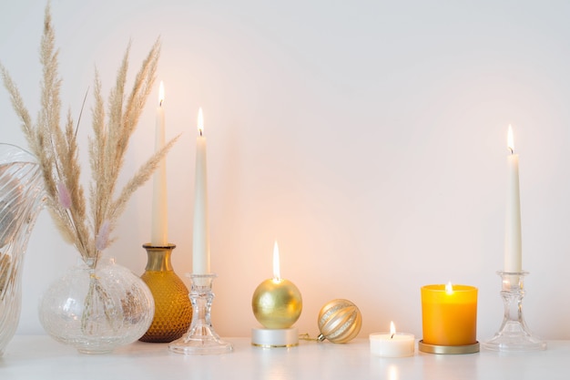 Christmas decorations with burning candles in white room