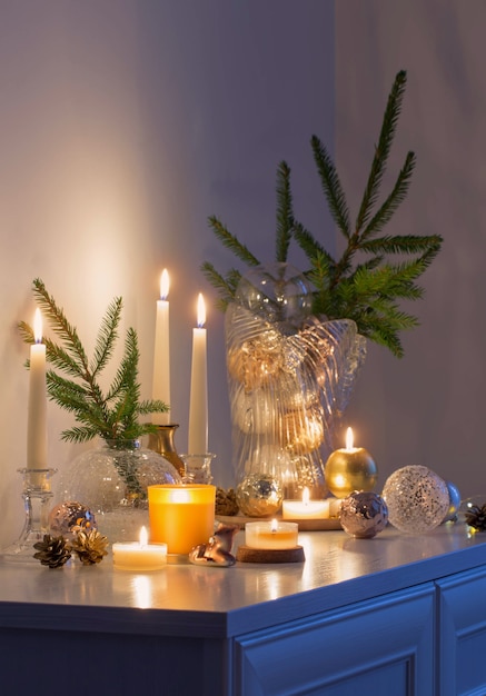 Christmas decorations with burning candles in white room