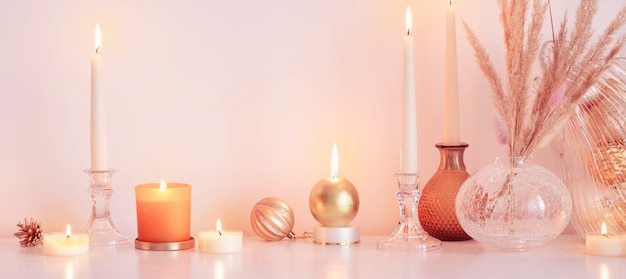 Christmas decorations with burning candles in white room