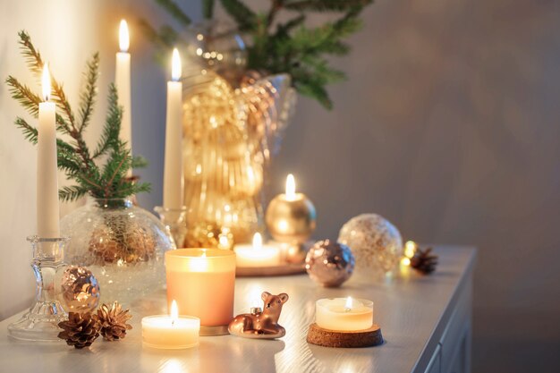 Christmas decorations with burning candles in white room