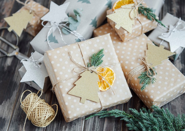 Christmas  decorative homemade gift boxes wrapped in brown kraft paper on a dark gray wooden background