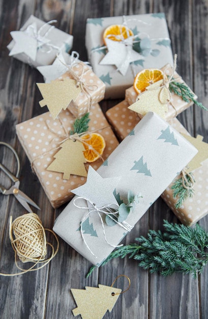 Christmas  decorative homemade gift boxes wrapped in brown kraft paper on a dark gray wooden background