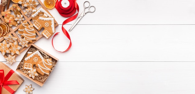 Christmas dessert. Gingerbread cookies in box on white wooden background, top view, copy space