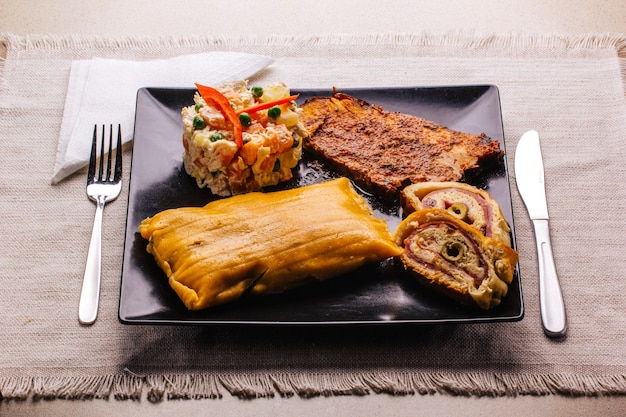 Christmas dish in Venezuela, hallaca, ham bread, salad and pork