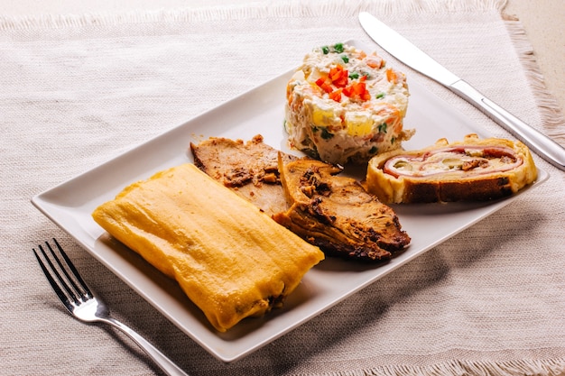 Christmas dish in Venezuela, hallaca, ham bread, salad and pork