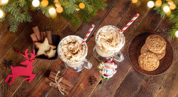 Christmas eggnog cinnamon cookies decorations fir twigs Xmas lights on wooden table Top view