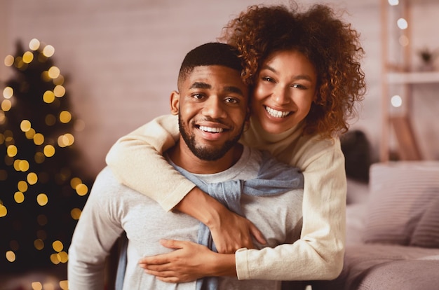 Photo christmas eve loving couple embracing and smiling to camera