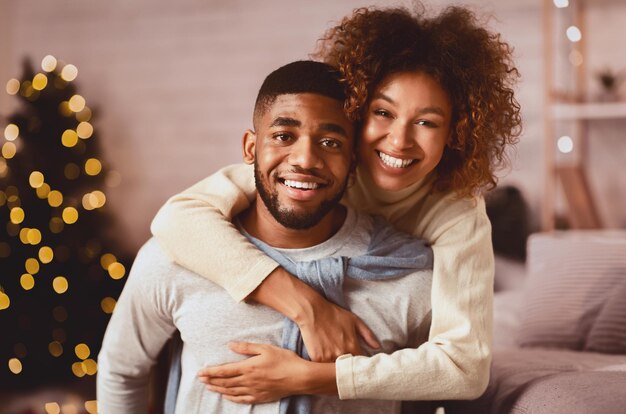 Photo christmas eve loving couple embracing and smiling to camera