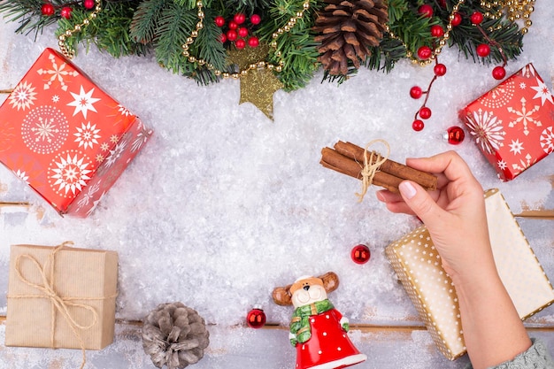 On a christmas festive background a female hand lays out decorations