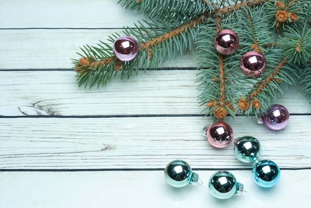 Christmas fir tree branch with decoration on white wooden board background