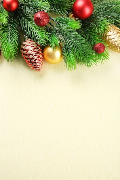 Christmas fir tree branches with toys on paper background