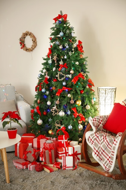 Christmas fir tree with gifts in living room