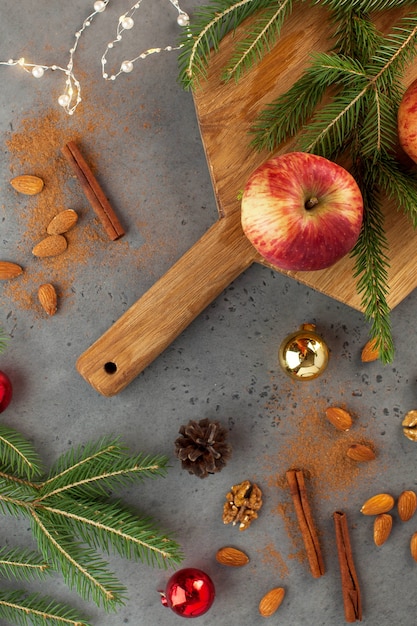 Christmas flatlay of apples, nuts, cinnamon and tree branches. The concept of Christmas and new year. Greeting card.