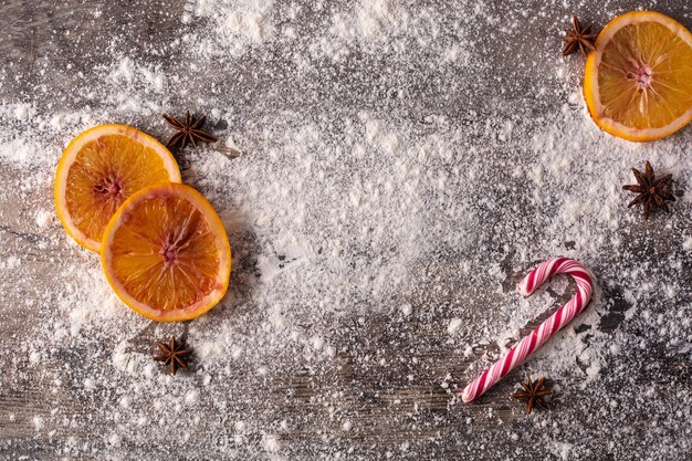 Christmas food background with oranges, star anise, and flour