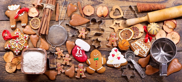 Christmas food.  Homemade gingerbread man cookies with ingredients for christmas cooking and kitchen utensils on wooden table, top view