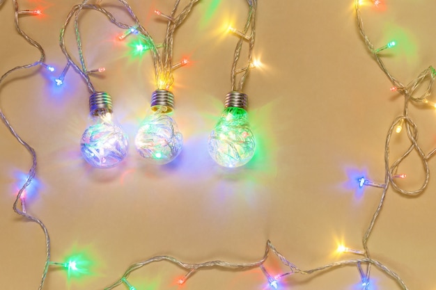 Christmas garlands in the form of light bulbs on a beige New Year's composition, Christmas concept,