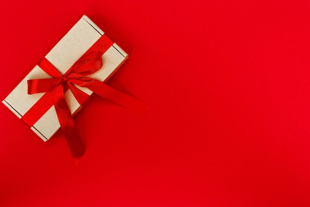 Christmas Gift box decorated with ribbon isolated on red