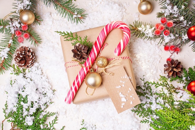 Christmas gift box, tree branches, pine cones and lollipop. New Year card. Flat lay style