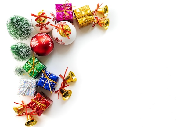 Christmas gift box and tree with golden bells, pine cones on white background