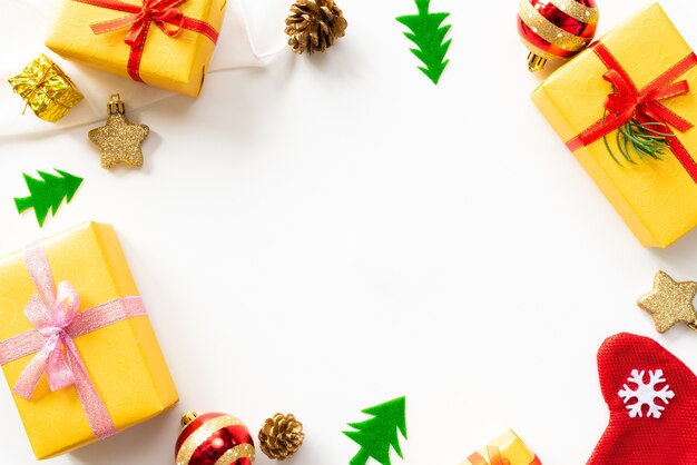 Christmas gift box with red ball and pine cones on white background.