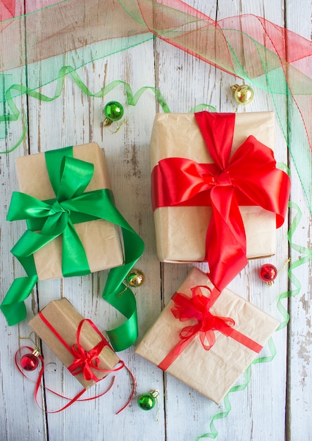 Christmas gift box with red ribbon and spruce branch on the white over pine cones